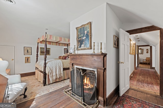 bedroom with vaulted ceiling and light hardwood / wood-style flooring