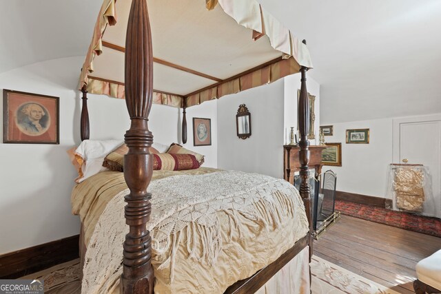 bedroom with lofted ceiling and light hardwood / wood-style floors