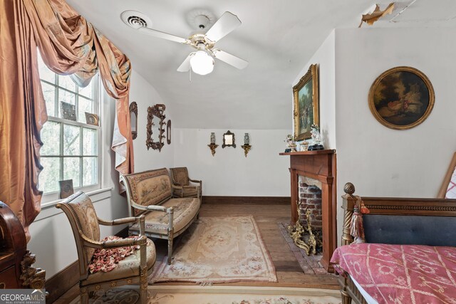 sitting room with hardwood / wood-style flooring, ceiling fan, and a fireplace