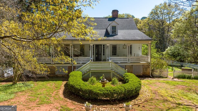 view of front of house with a porch and a front lawn