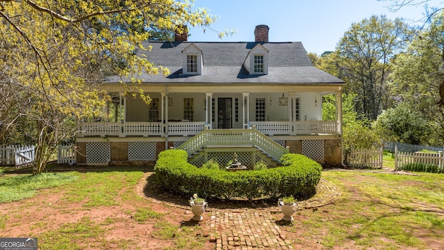 view of front facade featuring covered porch, french doors, and a front yard