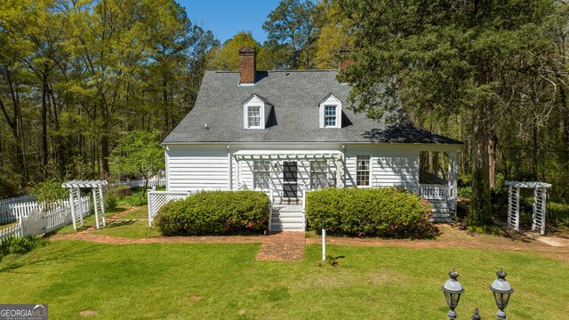 rear view of house featuring a lawn