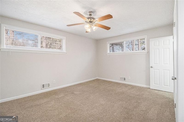 unfurnished room featuring a textured ceiling, ceiling fan, and carpet flooring