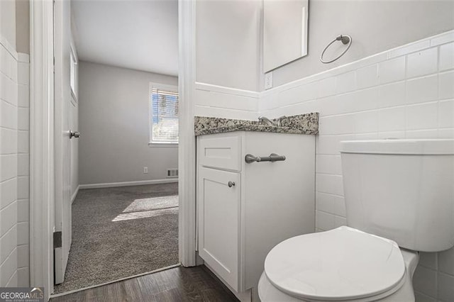 bathroom featuring toilet, vanity, and hardwood / wood-style floors