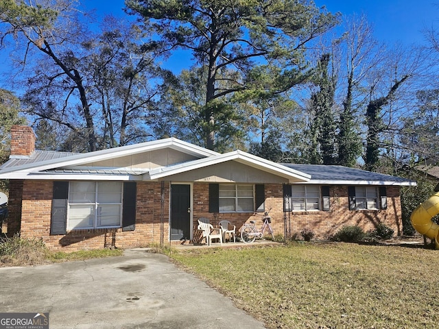 ranch-style home with a front yard and covered porch