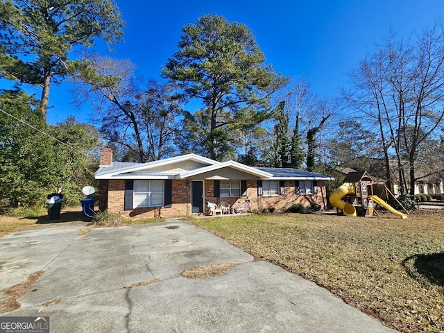 ranch-style house featuring a playground and a front lawn