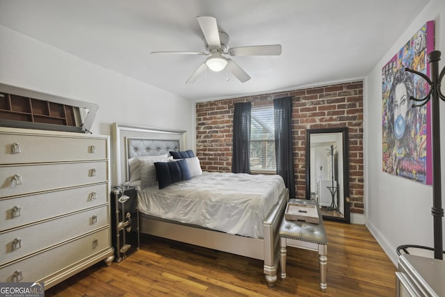 bedroom featuring ceiling fan, dark hardwood / wood-style flooring, and brick wall