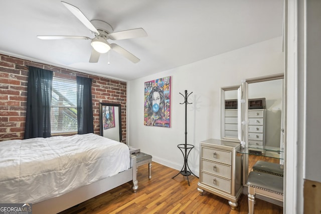 bedroom with ceiling fan, brick wall, and hardwood / wood-style flooring