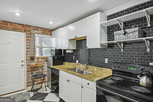 kitchen featuring white cabinets, black appliances, sink, backsplash, and light stone counters