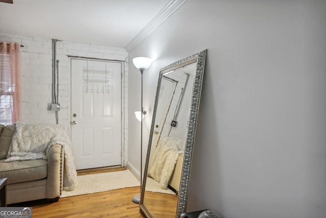 foyer with crown molding and hardwood / wood-style floors