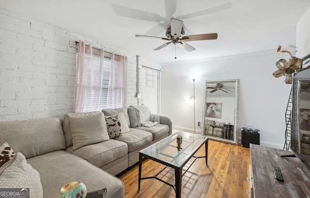 living room with brick wall, light hardwood / wood-style flooring, and ornamental molding