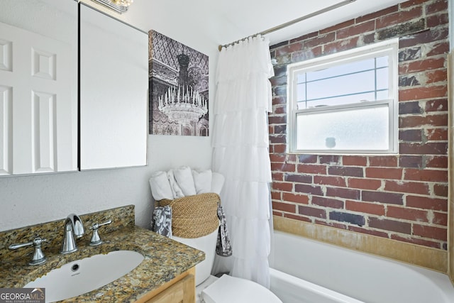 full bathroom with toilet, brick wall, shower / tub combo, and vanity