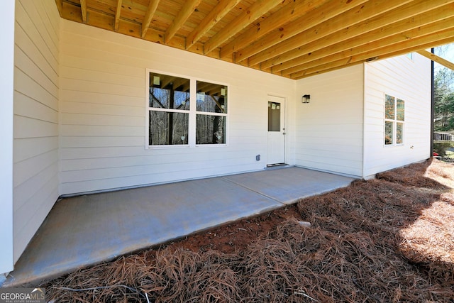 view of exterior entry with a patio area