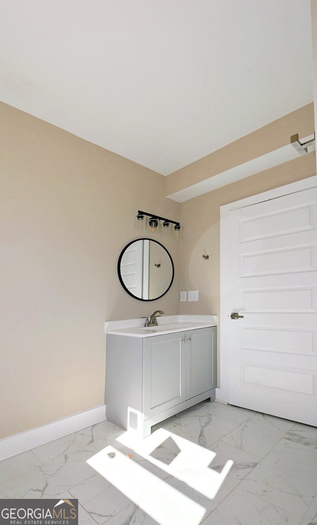 bathroom featuring marble finish floor, vanity, and baseboards