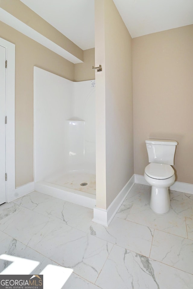 bathroom featuring a stall shower, marble finish floor, baseboards, and toilet