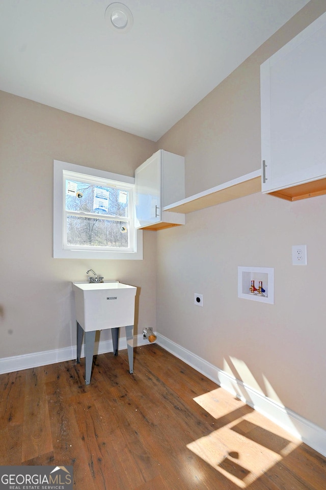 clothes washing area with washer hookup, baseboards, cabinet space, hardwood / wood-style floors, and electric dryer hookup