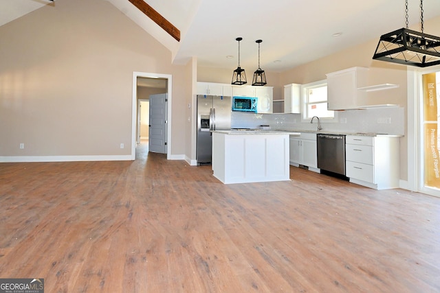 kitchen featuring a center island, open shelves, stainless steel appliances, hanging light fixtures, and white cabinetry