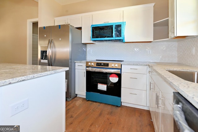 kitchen with light wood-type flooring, white cabinetry, appliances with stainless steel finishes, and light stone counters