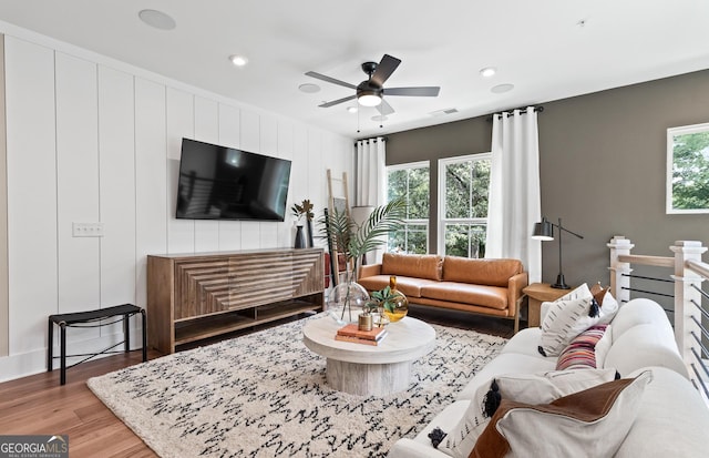 living room featuring light wood-type flooring and ceiling fan