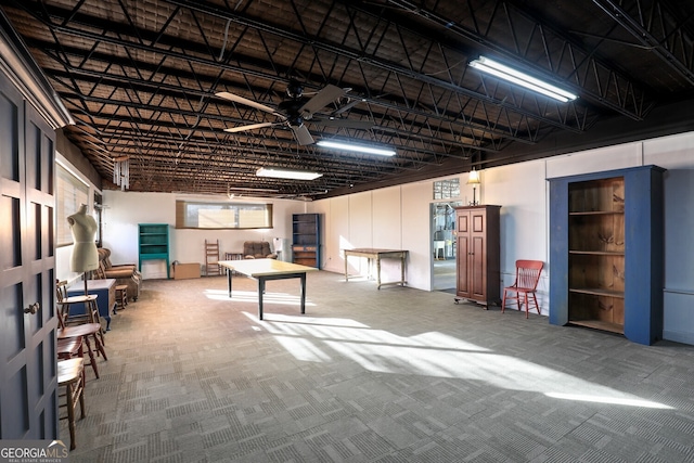 basement with carpet floors and ceiling fan