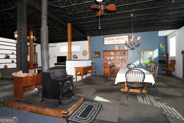 dining space with ceiling fan and a wood stove