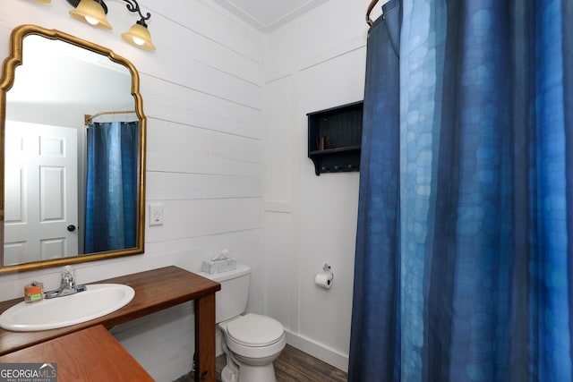 bathroom with toilet, wood-type flooring, and vanity