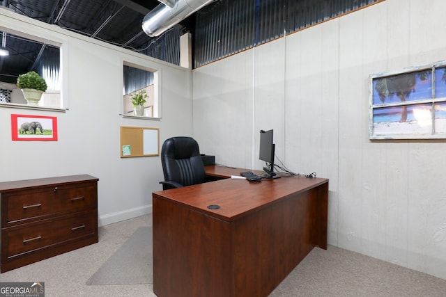 office space featuring wood walls and light colored carpet