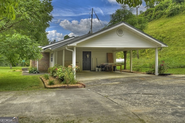 view of front of property featuring a front yard and a carport