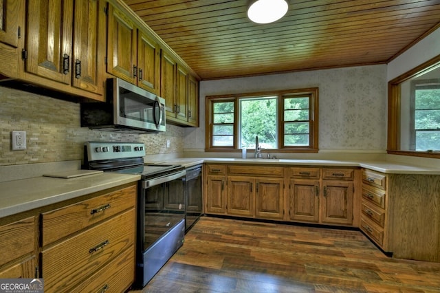 kitchen with sink, ornamental molding, dark hardwood / wood-style flooring, wood ceiling, and appliances with stainless steel finishes