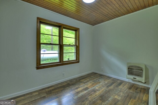 spare room with dark wood-type flooring, wood ceiling, and heating unit