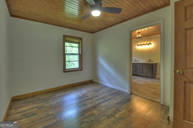 spare room featuring dark wood-type flooring, ceiling fan, crown molding, and wood ceiling