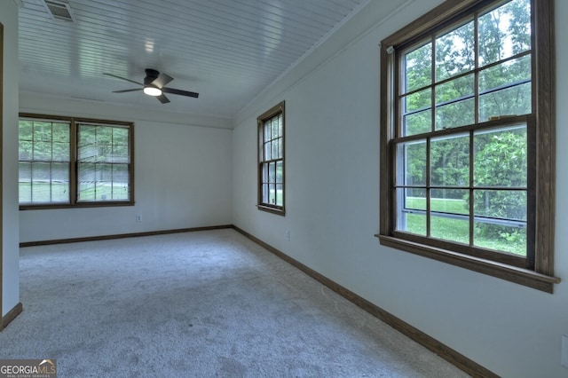 carpeted empty room with ceiling fan and ornamental molding