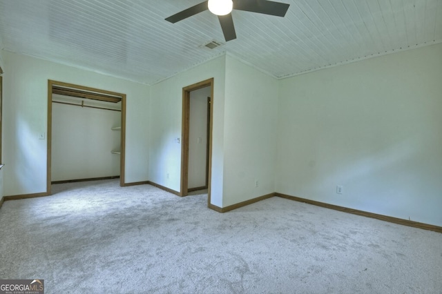 unfurnished bedroom featuring ceiling fan, a closet, and light carpet