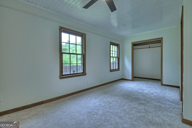 unfurnished bedroom featuring light carpet, a closet, and ceiling fan