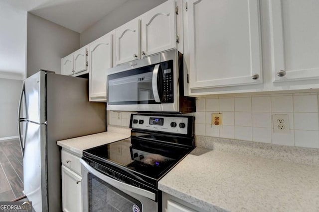 kitchen featuring decorative backsplash, white cabinetry, and appliances with stainless steel finishes