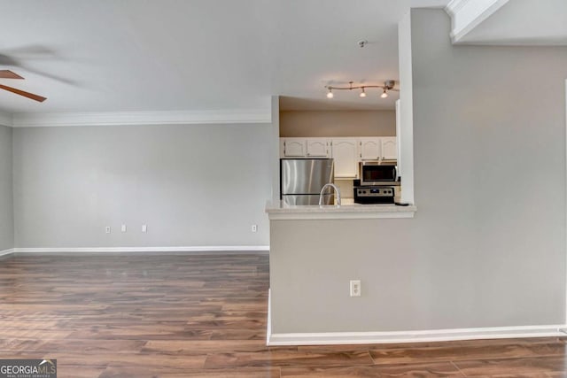 interior space featuring ceiling fan, ornamental molding, and dark hardwood / wood-style flooring