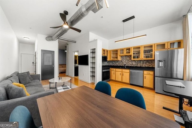 kitchen with ceiling fan, appliances with stainless steel finishes, sink, decorative light fixtures, and decorative backsplash