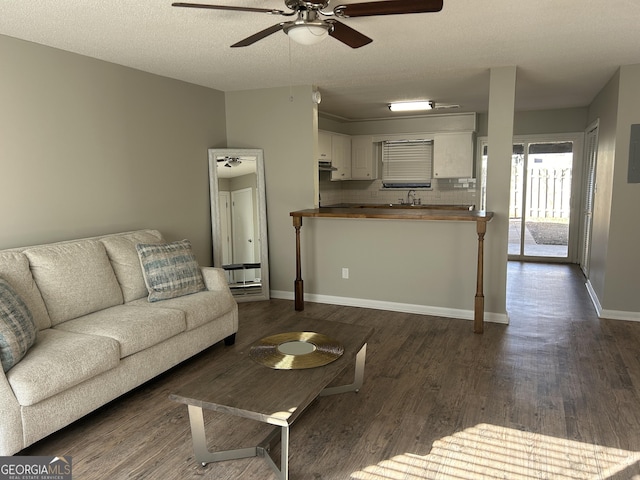 living room with sink, ceiling fan, a textured ceiling, and dark hardwood / wood-style floors