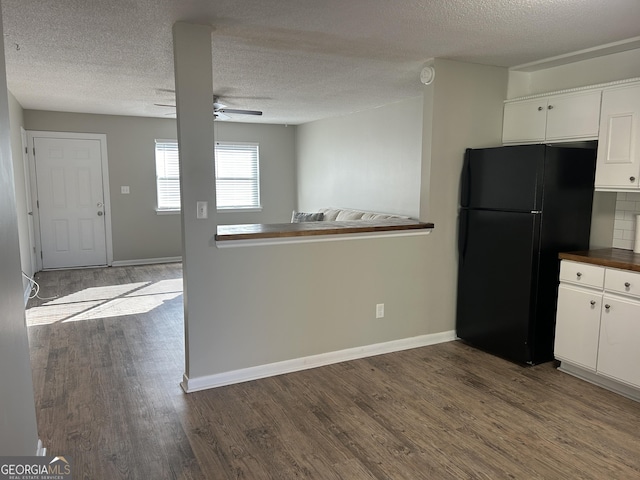 kitchen with black refrigerator, ceiling fan, dark hardwood / wood-style floors, a textured ceiling, and white cabinetry