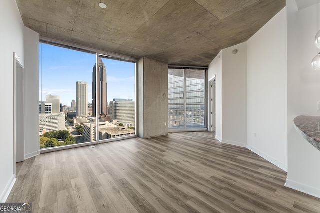 interior space with a healthy amount of sunlight, expansive windows, and hardwood / wood-style flooring