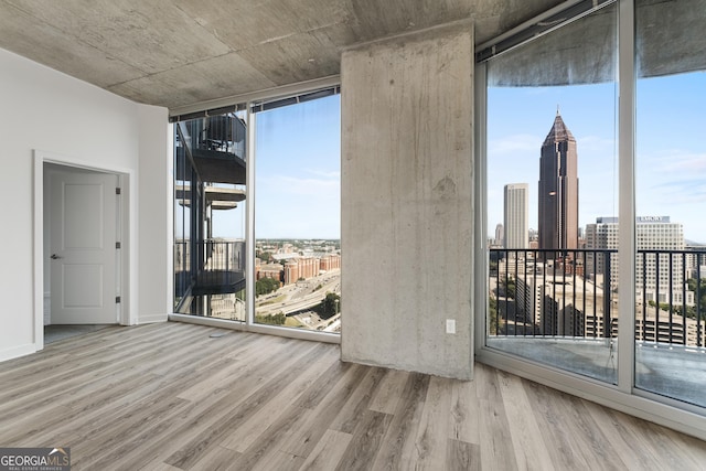 unfurnished room featuring hardwood / wood-style floors and floor to ceiling windows