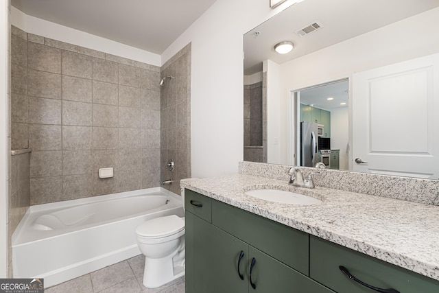 full bathroom featuring vanity, tile patterned flooring, tiled shower / bath combo, and toilet