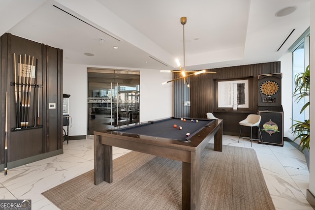 game room featuring pool table, wood walls, and a chandelier