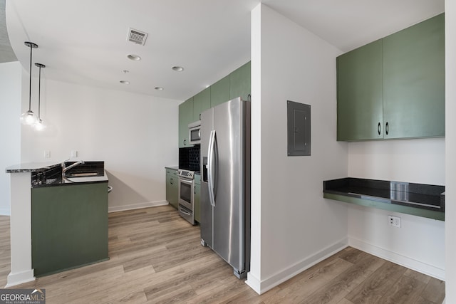 kitchen with appliances with stainless steel finishes, kitchen peninsula, electric panel, and green cabinets