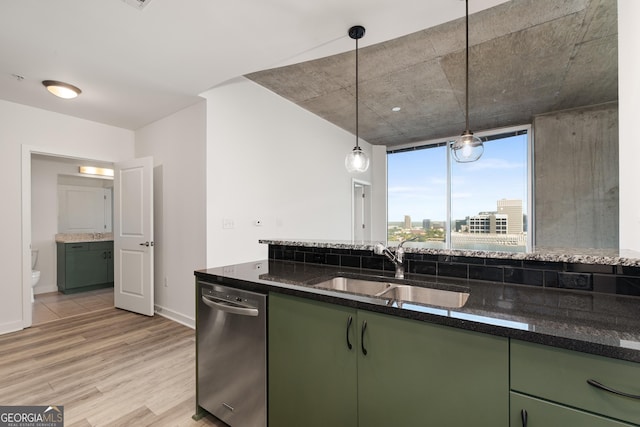 kitchen with hanging light fixtures, dark stone countertops, stainless steel dishwasher, and green cabinets