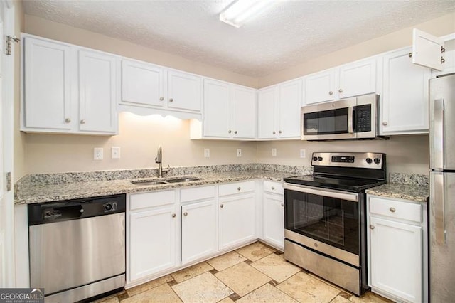 kitchen featuring appliances with stainless steel finishes, white cabinetry, a textured ceiling, and sink