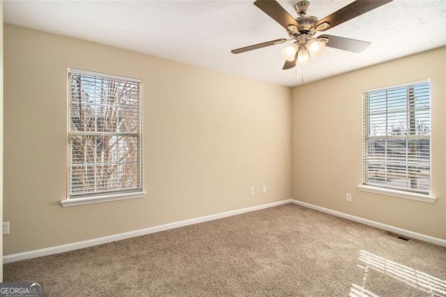 spare room featuring ceiling fan and carpet