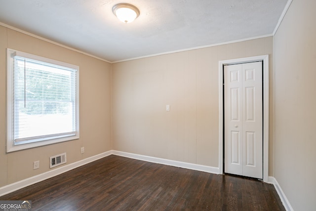 spare room with dark wood-type flooring and crown molding