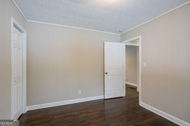 empty room featuring a textured ceiling, crown molding, and dark hardwood / wood-style flooring