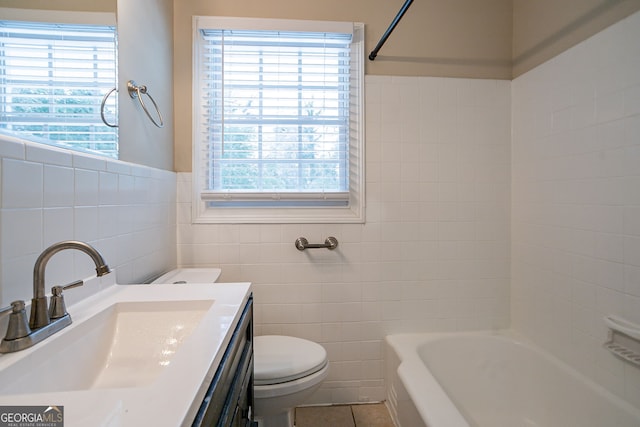 full bathroom with toilet, tile patterned flooring, bathing tub / shower combination, tile walls, and vanity